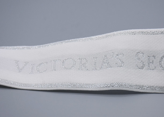 Одежда подгоняла ленту белого жаккарда 35mm эластичную с сияющим серебряным логотипом